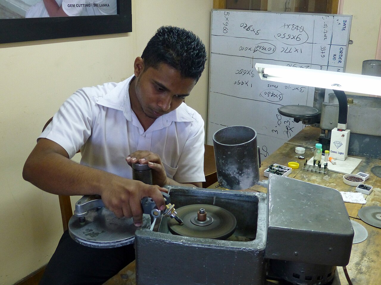 A gemstone cutter working at a polishing lap in Kandy, Sri Lanka